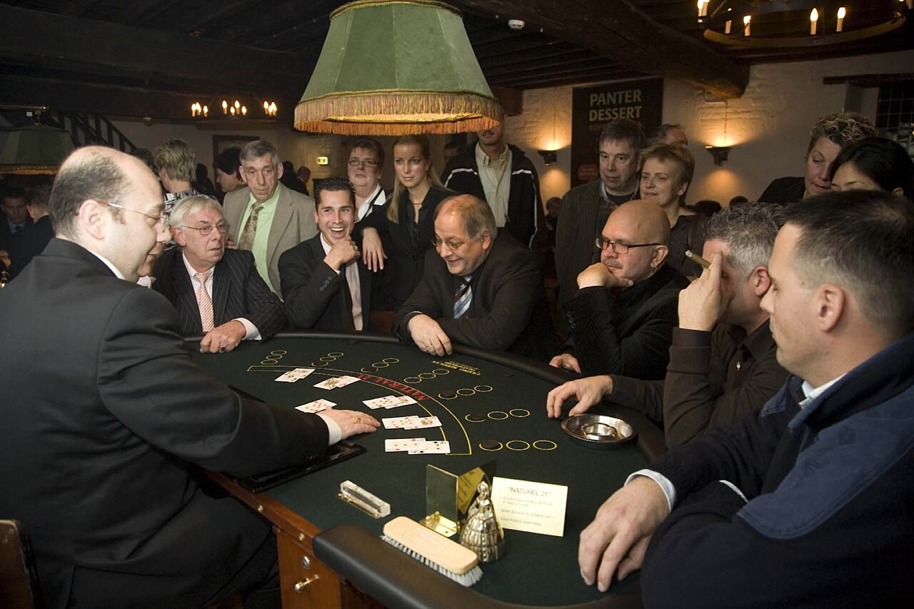 Dealer turning the final card slowly on a live baccarat table